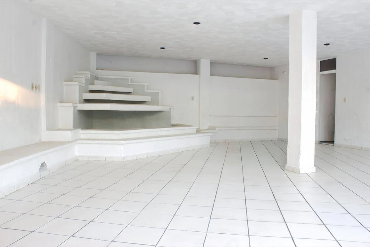 Terraza abierta amplia con plataforma elevada y columnas blancas en casa Bosques de las Lomas