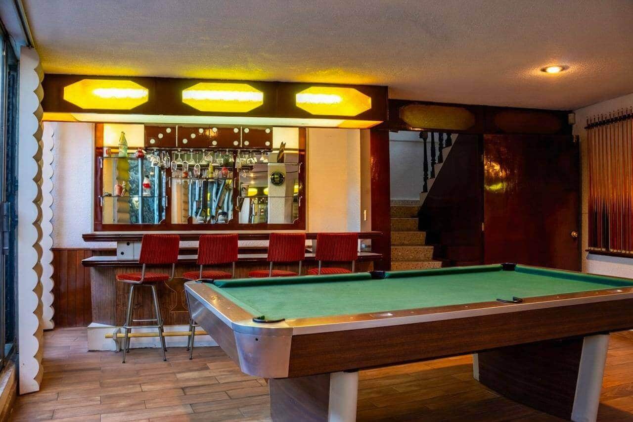 Sala de juegos con mesa de billar profesional y área de bar en casa de lujo en Bosques de las Lomas
