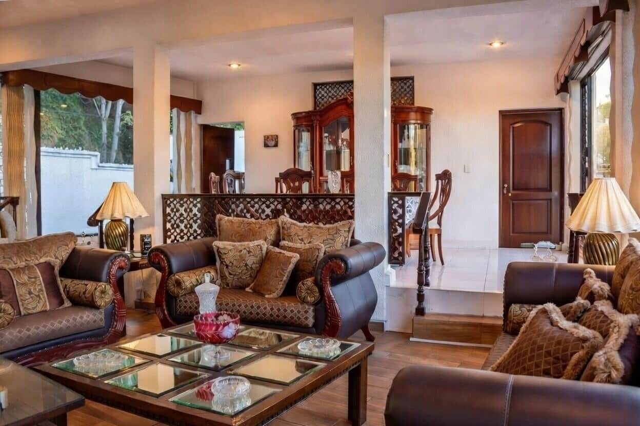 Sala principal formal amplia con sofás clásicos, mesas de centro y conexión abierta al comedor en casa Bosques de las Lomas